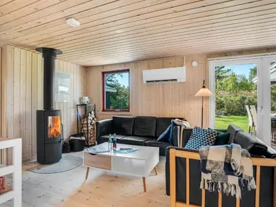 a living room with a couch and a fireplace at Holiday Home Rajna - 500m to the fjord by Interhome in Vestervig