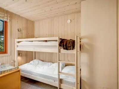 a room with two bunk beds and a refrigerator at Holiday Home Rajna - 500m to the fjord by Interhome in Vestervig