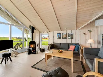 a living room with a couch and a table and a fireplace at Holiday Home Märta - 250m from the sea by Interhome in Lemvig