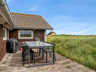 a wooden deck with a table and chairs on it at Holiday Home Märta - 250m from the sea by Interhome in Lemvig