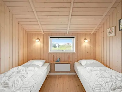 two beds in a room with a window at Holiday Home Märta - 250m from the sea by Interhome in Lemvig