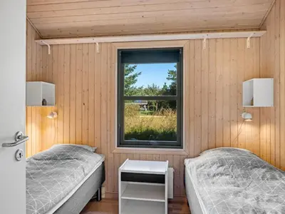 two beds in a room with a window at Holiday Home Matthea - 900m from the sea by Interhome in Fjerritslev