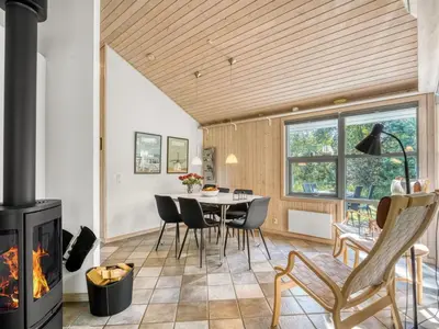 a living room with a fireplace and a table and chairs at Holiday Home Matthea - 900m from the sea by Interhome in Fjerritslev