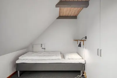 a bedroom with a bed in a white wall at Large Pool House With Activity Room Located In Peaceful Surroundings in Frøstrup