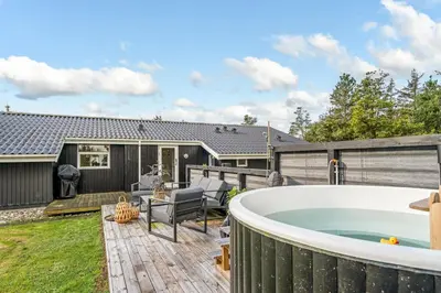 a backyard with a jacuzzi tub on a deck at Lovely Spa House In Scenic Surroundings in Thyholm