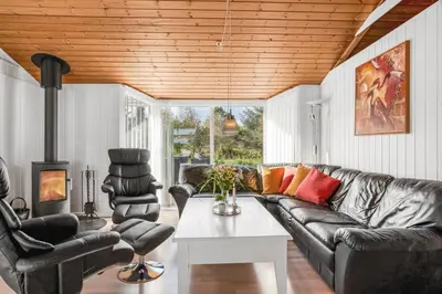 a living room with a leather couch and two chairs at Lovely Spa House In Scenic Surroundings in Thyholm