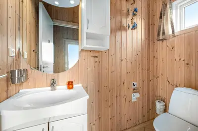a bathroom with a white sink and a mirror at Holiday Home With Spa And Sauna, Just 200 Meters From The North Sea in Frøstrup