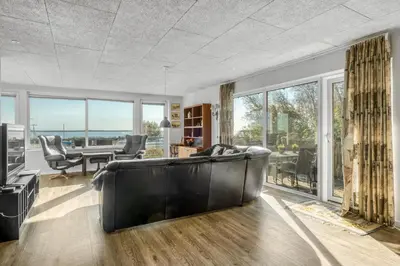 a living room with a couch and a table at Large Holiday Home With A View Of The Fjord in Thyholm