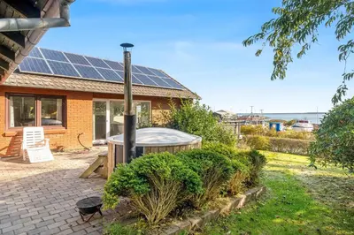 a house with solar panels on the roof at Large Holiday Home With A View Of The Fjord in Thyholm