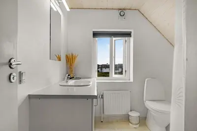 a bathroom with a sink and a toilet at Pool And Activity House With A Fantastic View Of The North Sea in Frøstrup