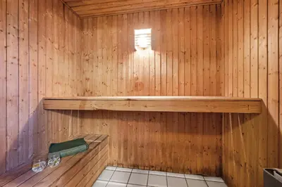 a wooden sauna with a bench and a window at Pool And Activity House With A Fantastic View Of The North Sea in Frøstrup