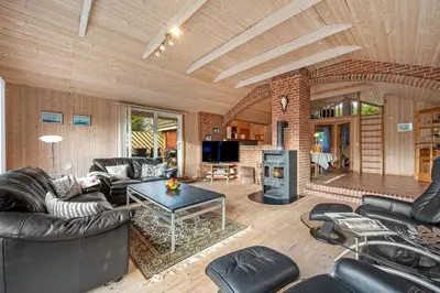 a living room with leather furniture and a fireplace at Cozy And Spacious Holiday Home Near Torup Strand Close To The North Sea in Fjerritslev