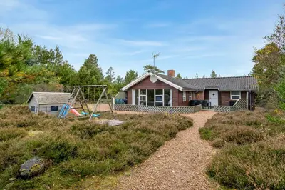 a house with a swing and a playground at Cozy And Spacious Holiday Home Near Torup Strand Close To The North Sea in Fjerritslev