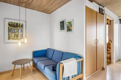 a living room with a blue couch and a table at Lovely Holiday Home With Panoramic Views Of The North Sea in Frøstrup