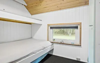 a small bedroom with a bed and a window at Cozy Home In Spøttrup With Wifi in Spottrup