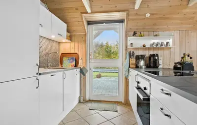a kitchen with white cabinets and a door with a window at Cozy Home In Spøttrup With Wifi in Spottrup