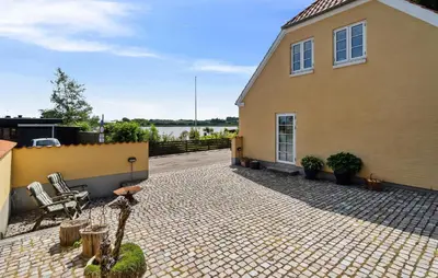 a house with a patio with chairs and a building at Amazing Home In Hurup Thy in Doverodde