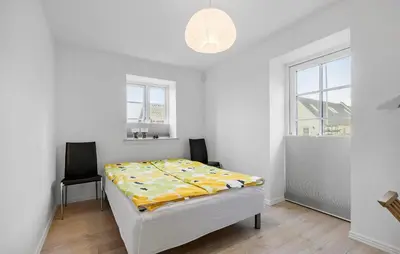 a white bedroom with a bed and two chairs at Amazing Home In Hurup Thy in Doverodde