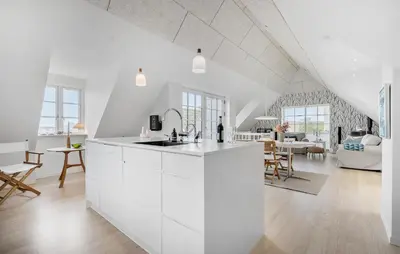 a kitchen with white cabinets and a living room at Amazing Home In Hurup Thy in Doverodde