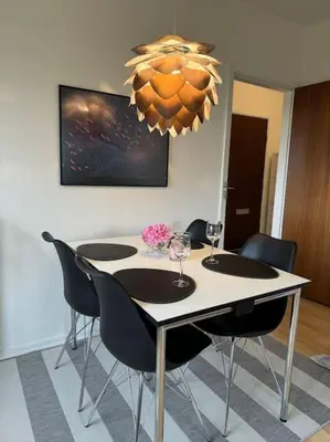 a dining room table with chairs and a chandelier at Stor og Lys Lejlighed i Hjertet af Holstebro in Holstebro