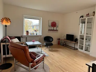 a living room with a couch and a table at Stor og Lys Lejlighed i Hjertet af Holstebro in Holstebro