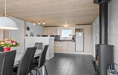 a kitchen and dining room with a table and a stove at 2 Bedroom Cozy Home In Thisted in Thisted