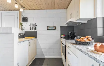 a kitchen with white cabinets and a basket of bread at 2 Bedroom Cozy Home In Thisted in Thisted