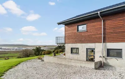 a house on a gravel road next to a building at Cozy Home In Hanstholm With Wifi in Hanstholm