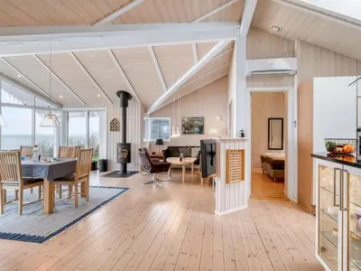 a living room with a table and a dining room at Holiday Home Næwe - 10m to the fjord by Interhome in Roslev