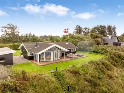 a house on a hill with a flag on it at Holiday Home Næwe - 10m to the fjord by Interhome in Roslev