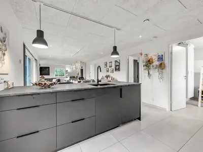 a large white kitchen with a large counter top at Holiday Home Elisaveta - 400m to the fjord by Interhome in Vemb