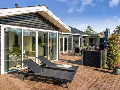 a patio with two chairs and a table on a deck at Holiday Home Elisaveta - 400m to the fjord by Interhome in Vemb