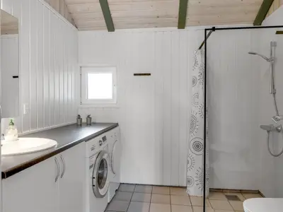 a white bathroom with a washing machine and a sink at Holiday Home Eftim - 500m from the sea by Interhome in Harboør