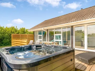 a hot tub on a deck with a house at Holiday Home Eftim - 500m from the sea by Interhome in Harboør
