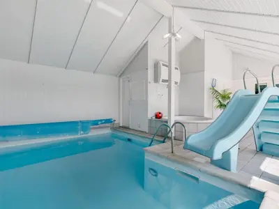 a swimming pool with a blue slide in a house at Holiday Home Eftim - 500m from the sea by Interhome in Harboør