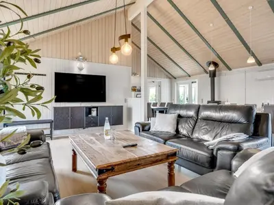 a living room with a couch and a table at Holiday Home Eftim - 500m from the sea by Interhome in Harboør