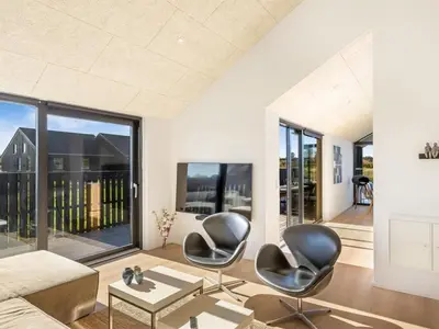 a living room with two chairs and a couch at Holiday Home Stenkil - 1-2km from the sea by Interhome in Løkken