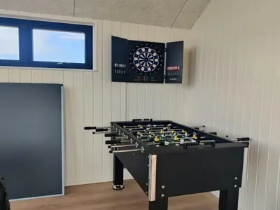 a large pool table in a room with a dartboard at Holiday Home Stenkil - 1-2km from the sea by Interhome in Løkken