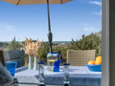 a table with an umbrella and a bowl of oranges at Holiday Home Sella - 600m from the sea by Interhome in Blokhus