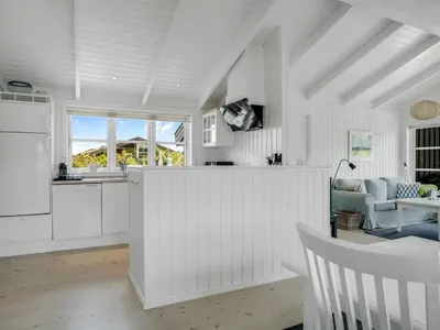 a kitchen with white cabinets and a table and chairs at Holiday Home Ljupco - 950m from the sea by Interhome in Saltum
