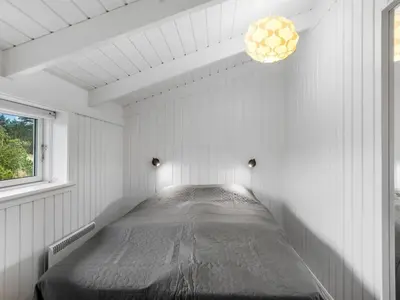 a white room with a bed in the corner at Holiday Home Ljupco - 950m from the sea by Interhome in Saltum