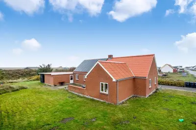 a red brick house with a green yard at Lovely Holiday House With 4 Rooms Close To The North Sea in Frøstrup