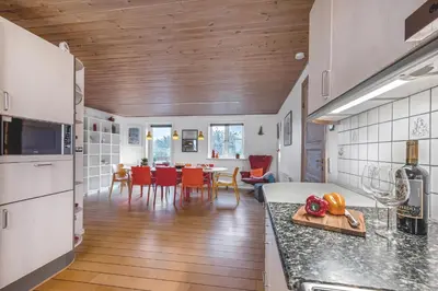 a kitchen and living room with a table and chairs at Lovely Holiday House With 4 Rooms Close To The North Sea in Frøstrup