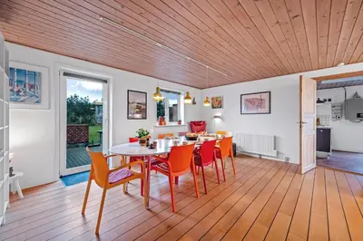 a dining room with a table and chairs at Lovely Holiday House With 4 Rooms Close To The North Sea in Frøstrup