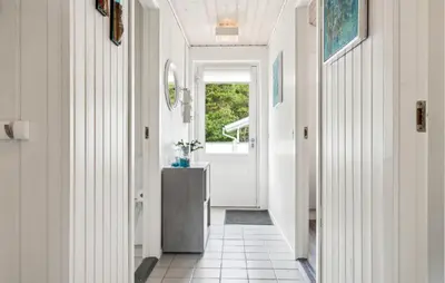 a hallway with white walls and a door with a table at Beautiful Home In Vestervig With Sauna in Vestervig