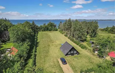 an aerial view of a house with a car on a field at 2 Bedroom Amazing Home In Spøttrup in Spottrup