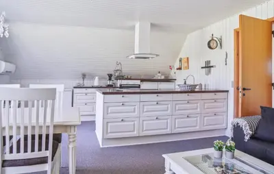 a kitchen with white cabinets and a table at 2 Bedroom Amazing Home In Spøttrup in Spottrup