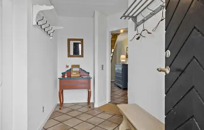 a hallway with a wooden door and a table at 5 Bedroom Lovely Home In Bøvlingbjerg in Bøvlingbjerg