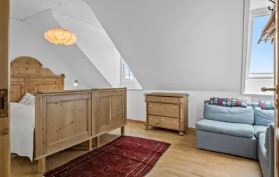 a bedroom with a bed and a blue couch at 5 Bedroom Lovely Home In Bøvlingbjerg in Bøvlingbjerg