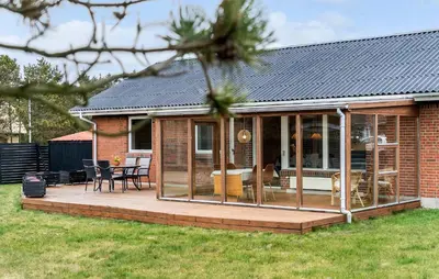 a house with a deck with a conservatory at Amazing Home In Vestervig With Wifi in Vestervig
